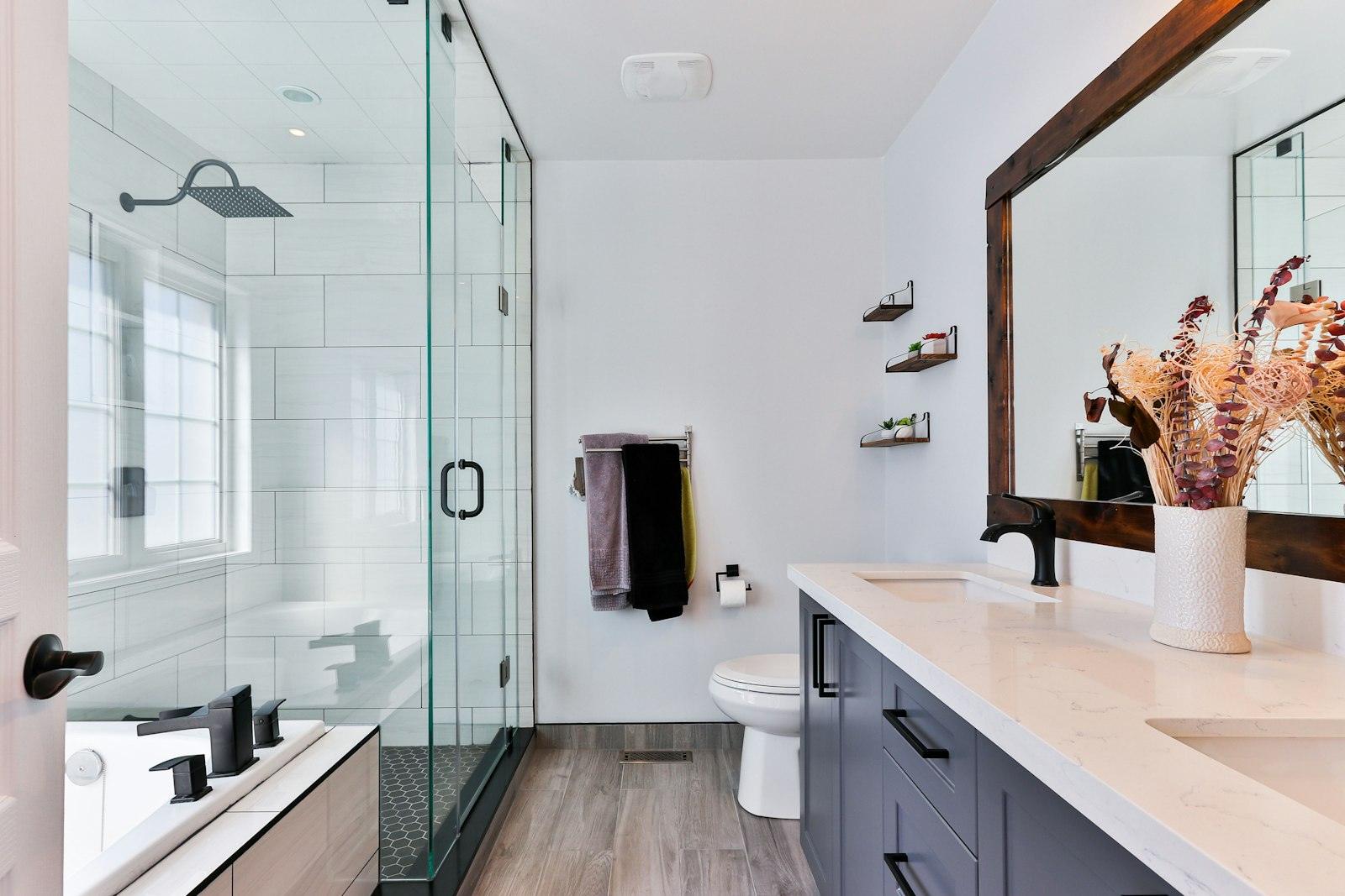 Bathroom with a white tiled shower and wood-look floor