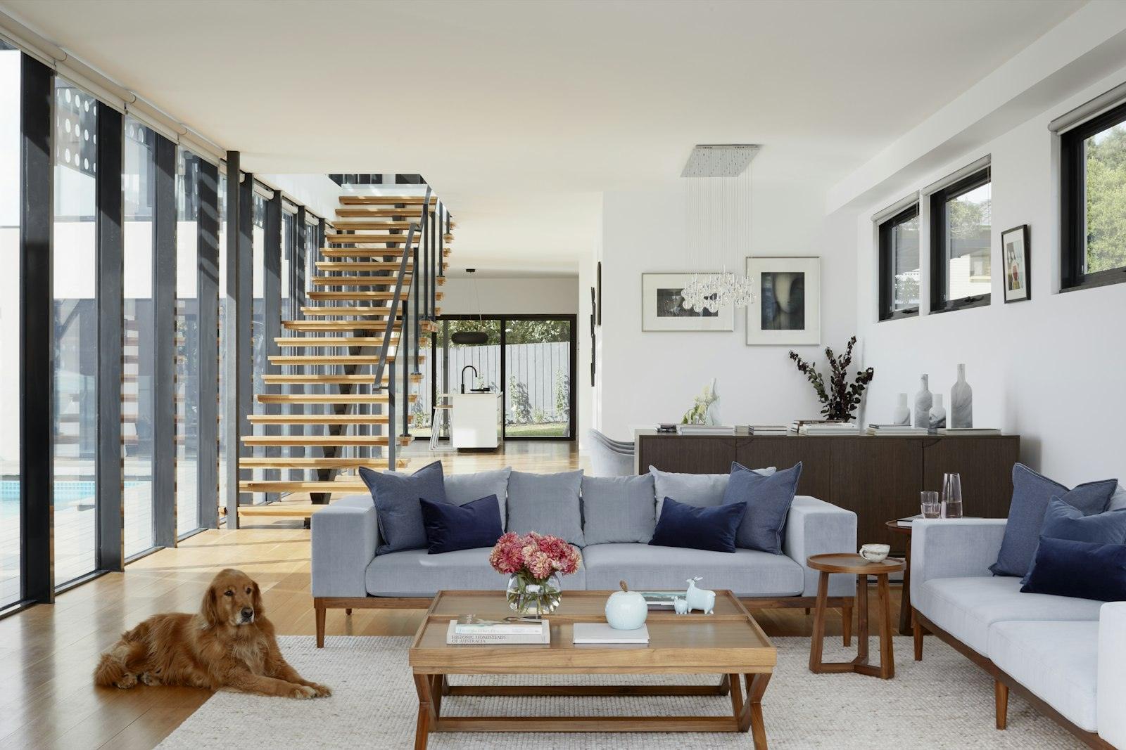 Open-plan living room with light wood floors and a stair